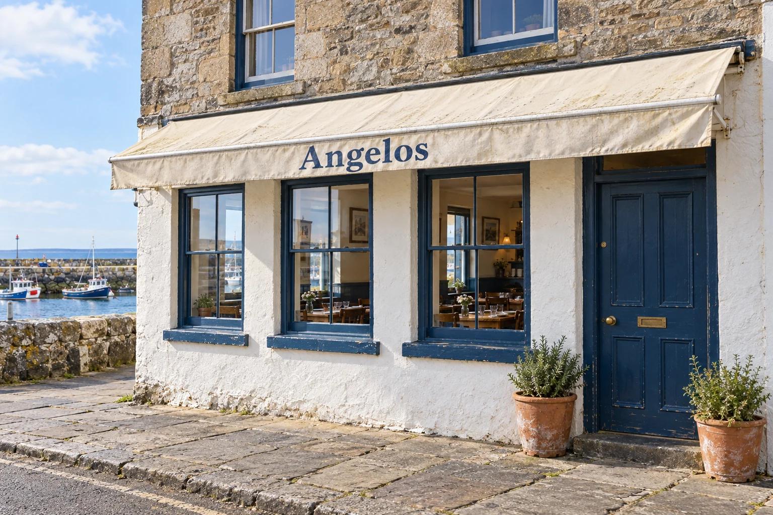 A modest pale-stone Angelos restaurant frontage with blue-painted timber and cream awning