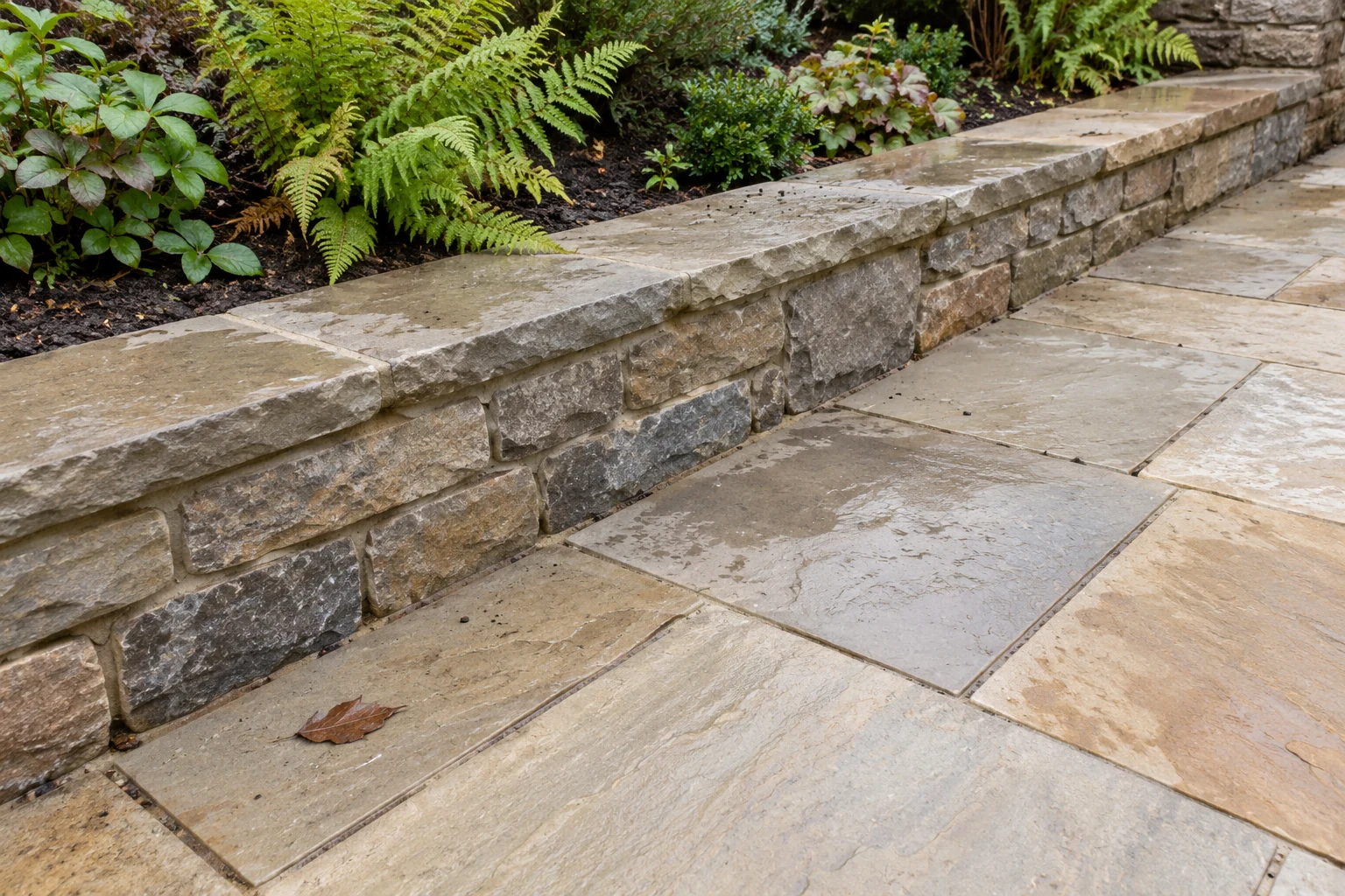 Weathered natural garden stone and carefully finished paving with planting at the edges